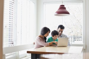 Parents showing son how to use a laptop Parents showing son how to use a laptop